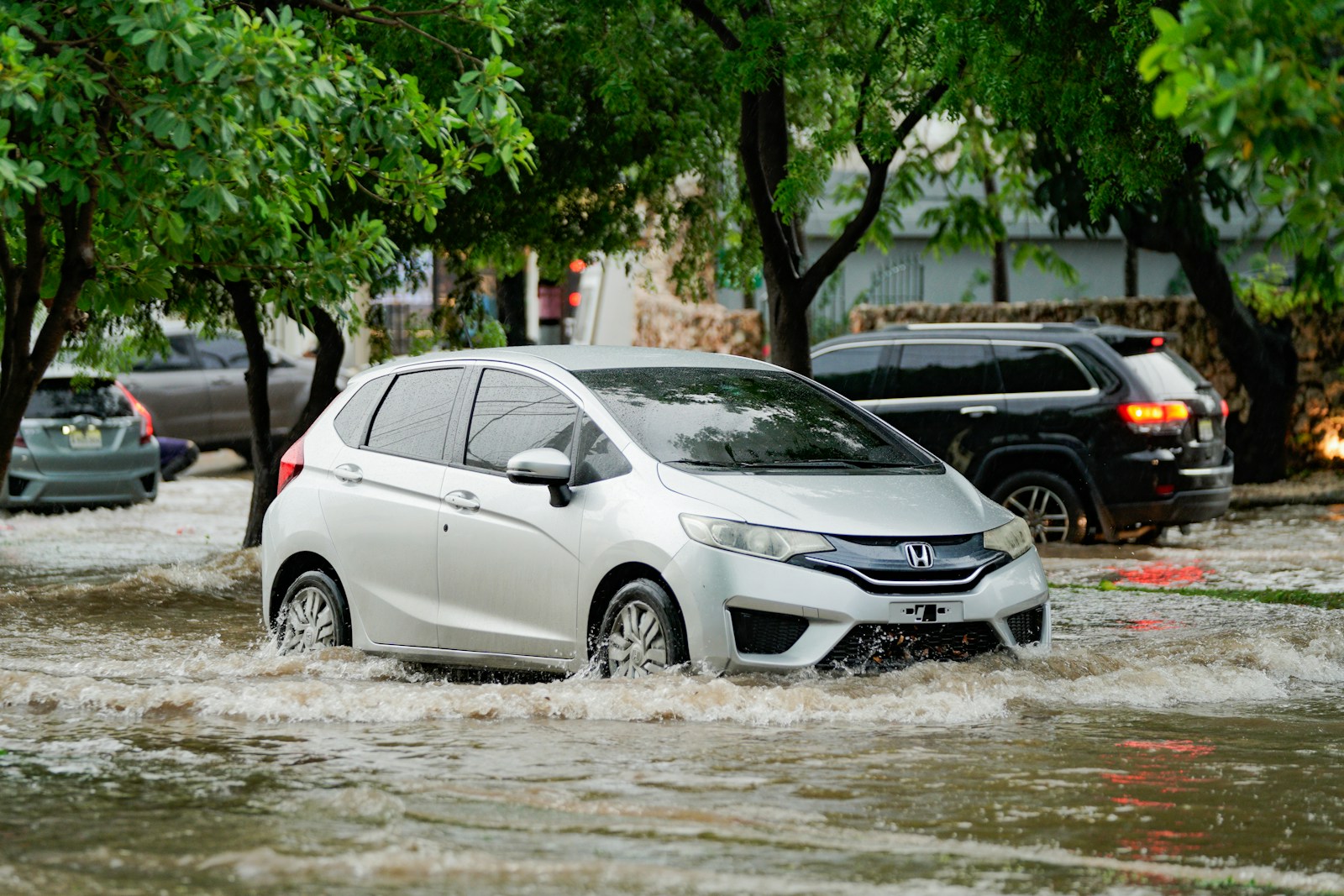 A white car driving through a flooded street
